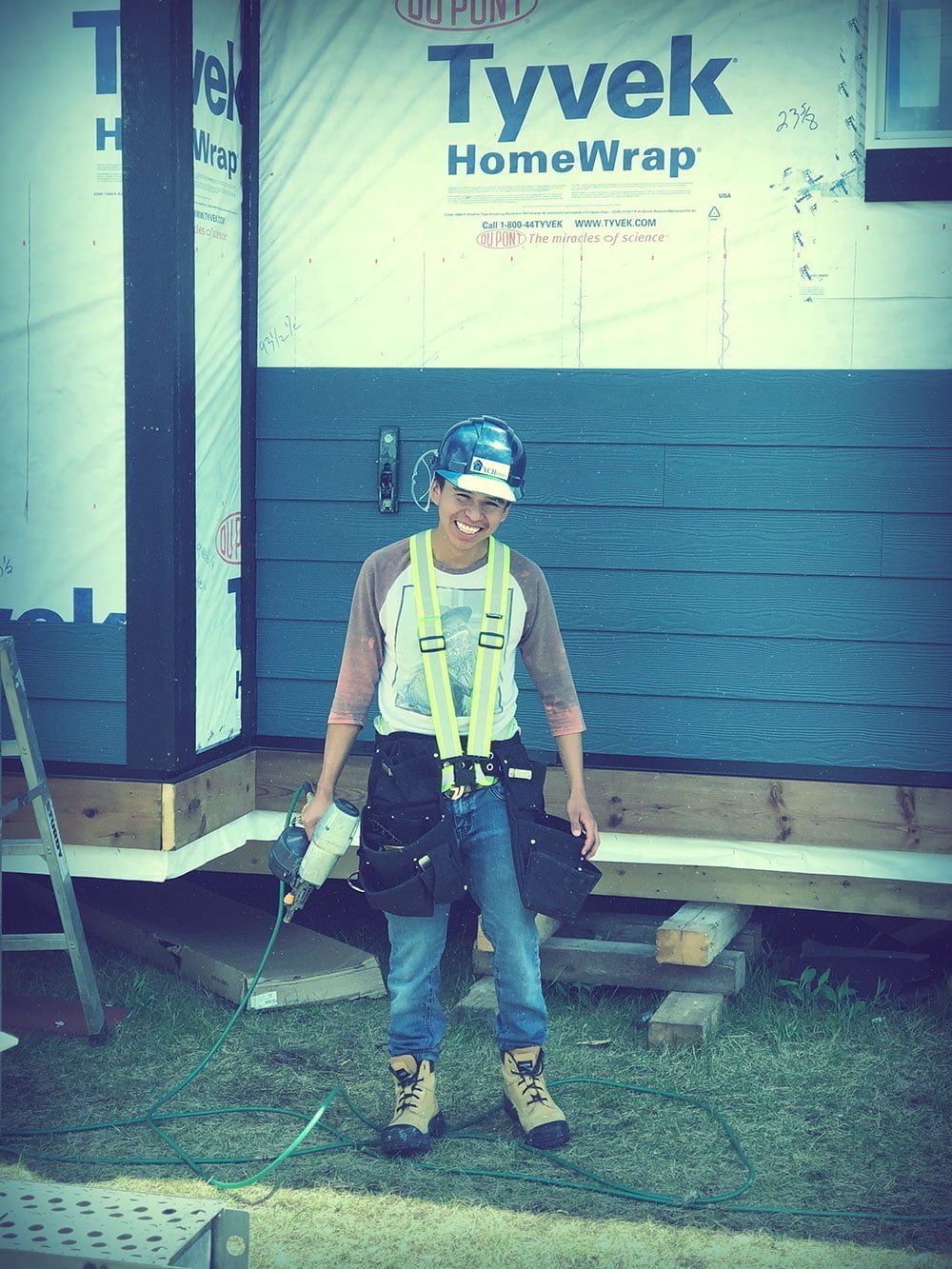 Image of a indigenous apprentice on a construction site holding a power tool